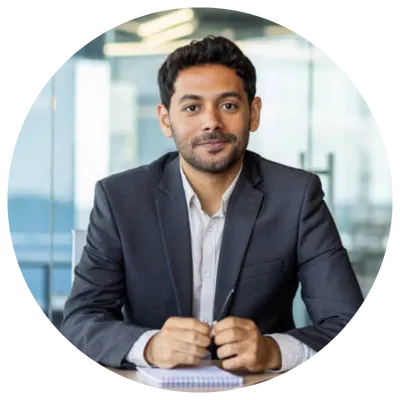 Man in a business suit sitting at a desk in a modern office.