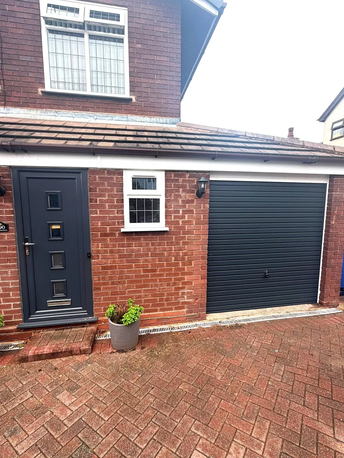 Before and after installation of an anthracite grey Garador Up & Over garage door in Dudley by Central Garage Doors.