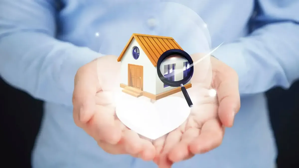 Mains tenant une maison miniature avec une loupe virtuelle, symbolisant l’évaluation de la valeur réelle d’un bien immobilier.