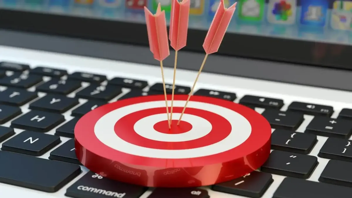 Fléchettes atteignant le centre d’une cible posée sur un clavier, symbolisant des conseils stratégiques pour optimiser assurance et prévoyance dans une gestion patrimoniale globale.