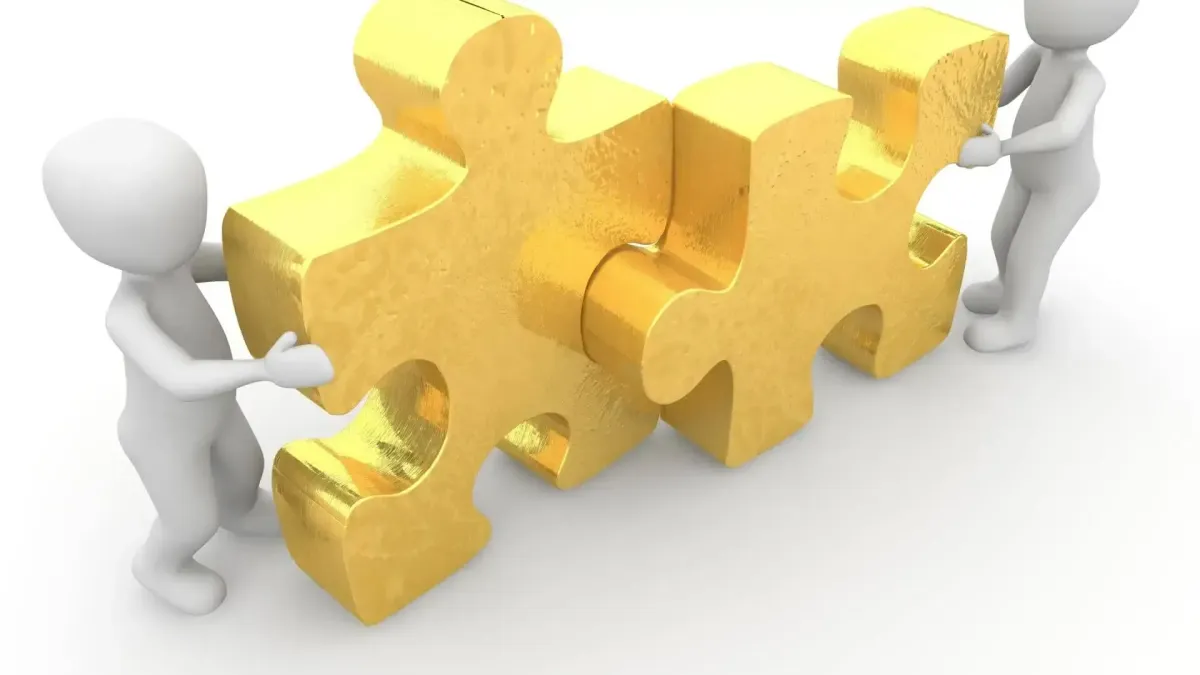 Pièces de puzzle dorées assemblées par des personnages, symbolisant la sélection de solutions de prévoyance personnalisées.