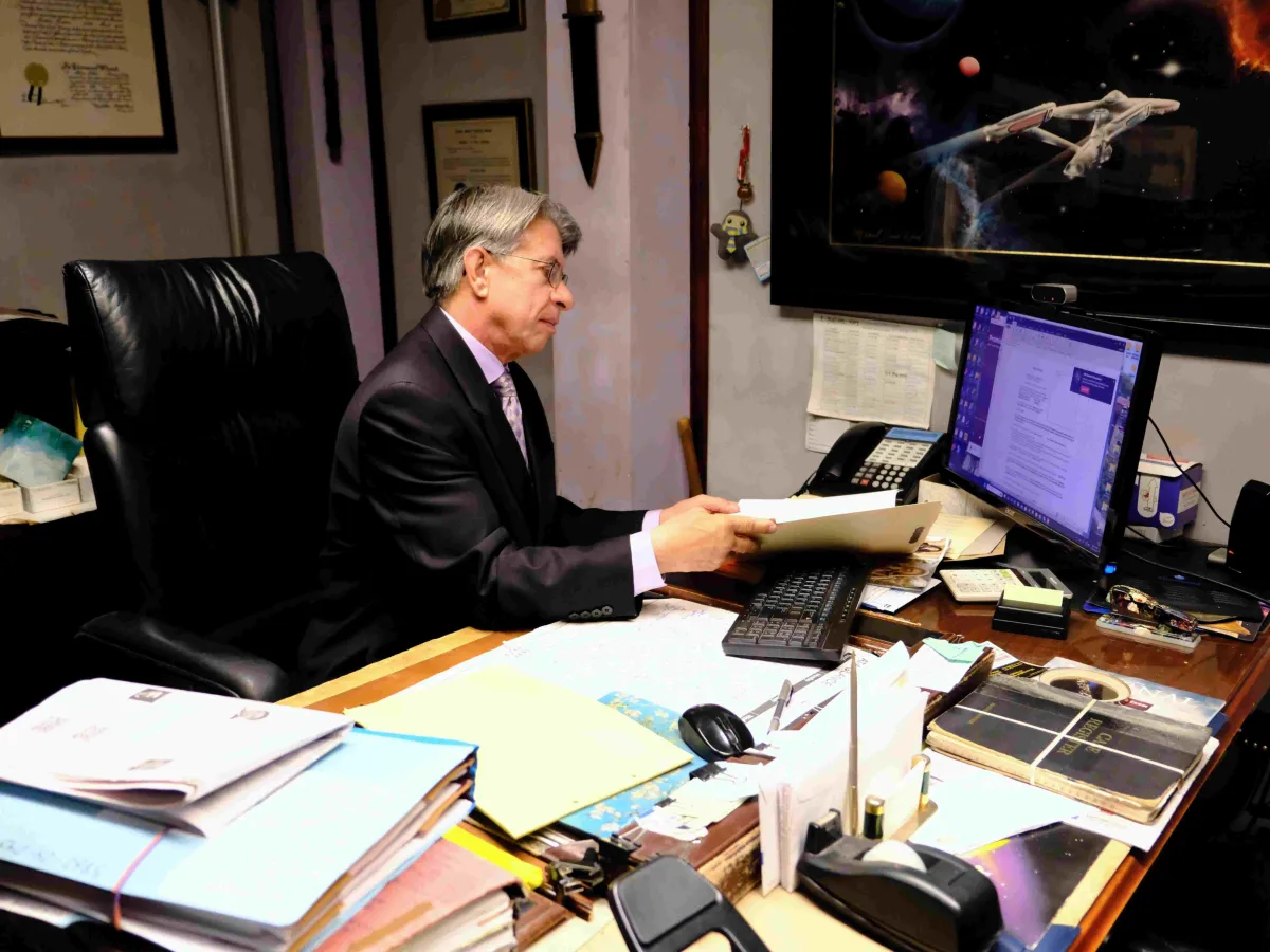 A Bronx personal injury lawyer sitting at his desk, reviewing legal documents and case files. The image represents professional legal services for injury victims seeking compensation.