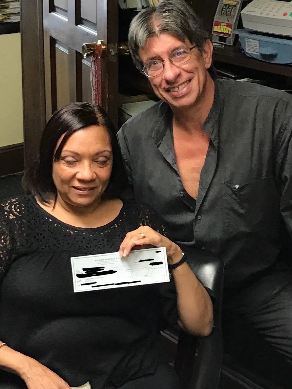 Bronx lawyer Matt with client holding settlement check after big firm dropped her case