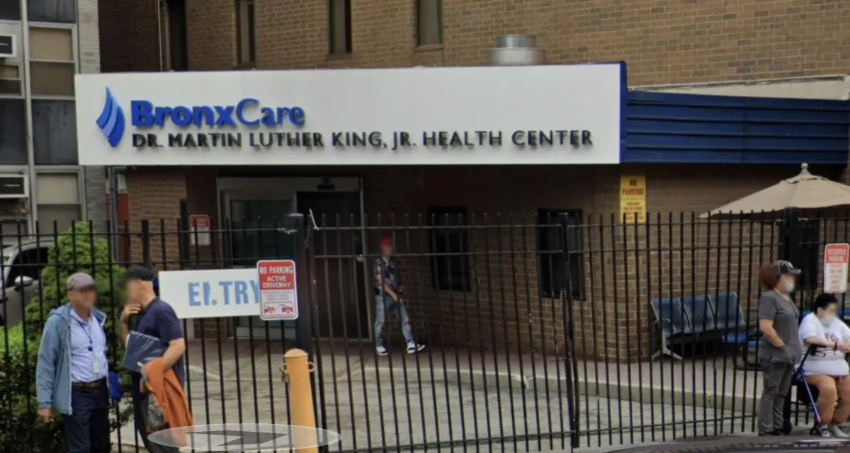 Entrance to BronxCare Dr. Martin Luther King, Jr. Health Center at 1276 Fulton Ave with people outside and gated entry.