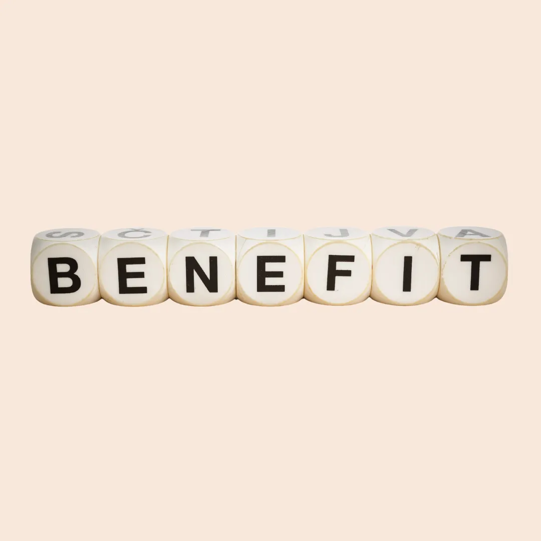 White dice spelling out the word "BENEFIT" on a soft beige background.