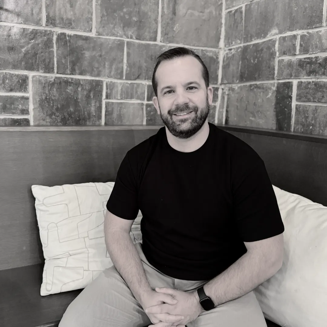 A picture of Ashley Frank sitting confidently looking into the camera.