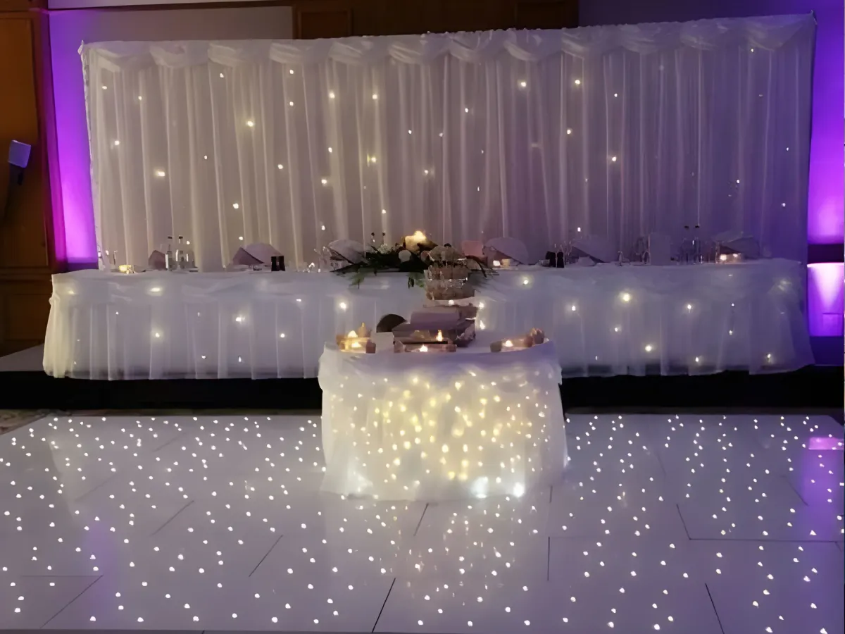 Starlit disco DJ booth with LED lights and guests dancing.