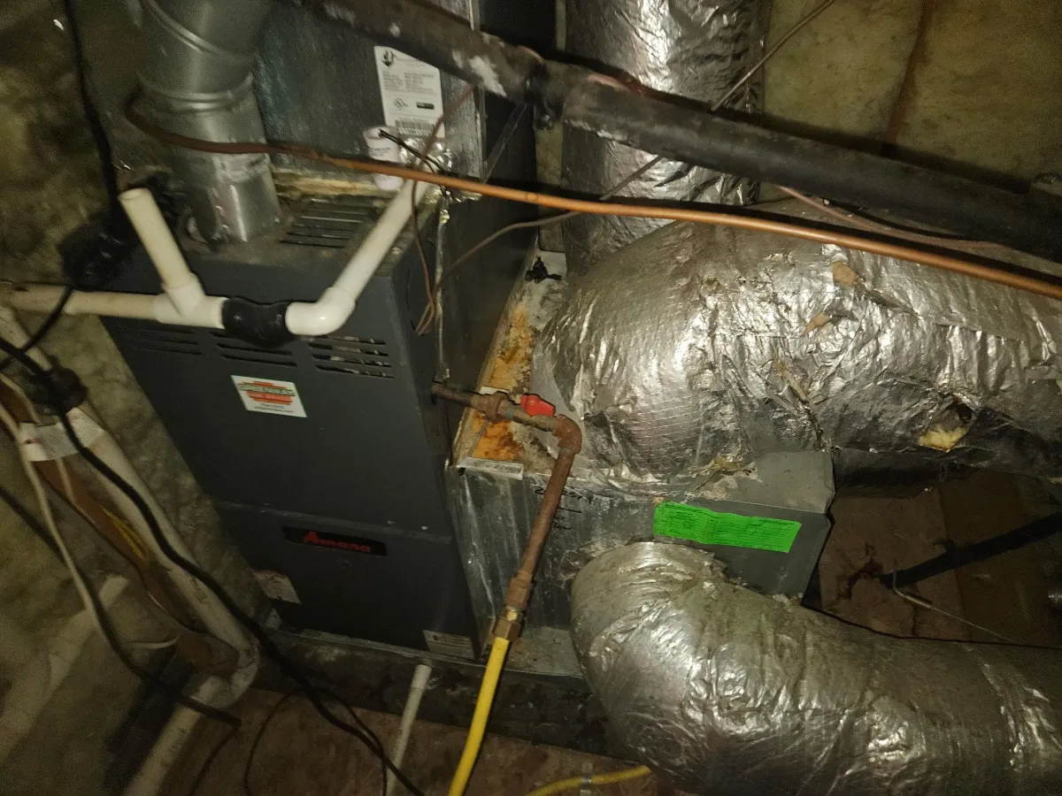 HVAC furnace system connected to insulated ductwork in crawlspace requiring duct inspection and repair
