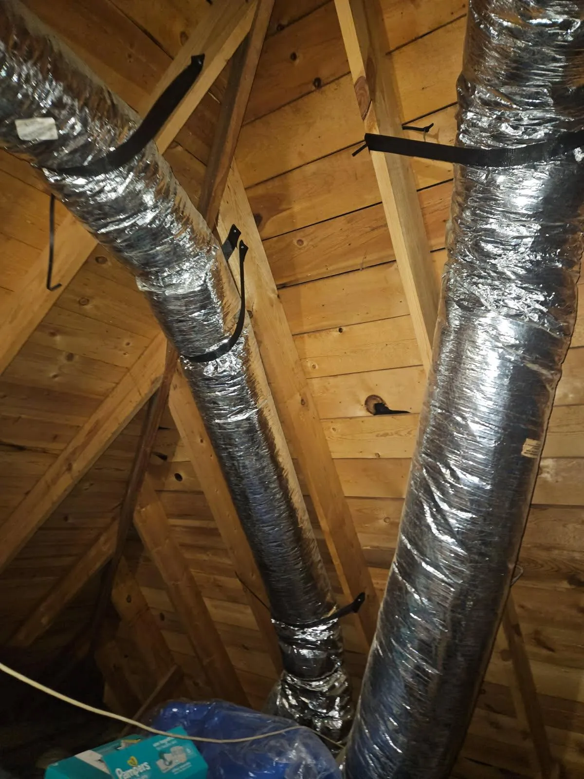 Residential HVAC attic flex duct installation properly strapped and insulated