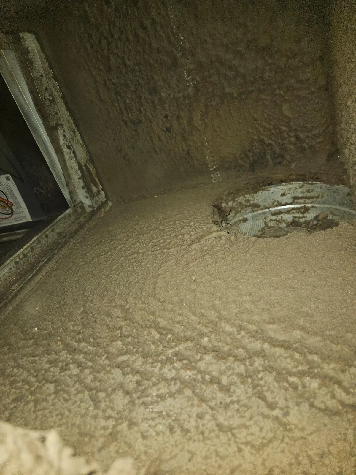 Dust buildup inside residential HVAC air duct before professional duct cleaning