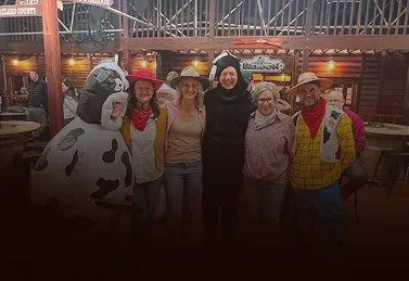 Friends in costumes having fun at the bowling alley.