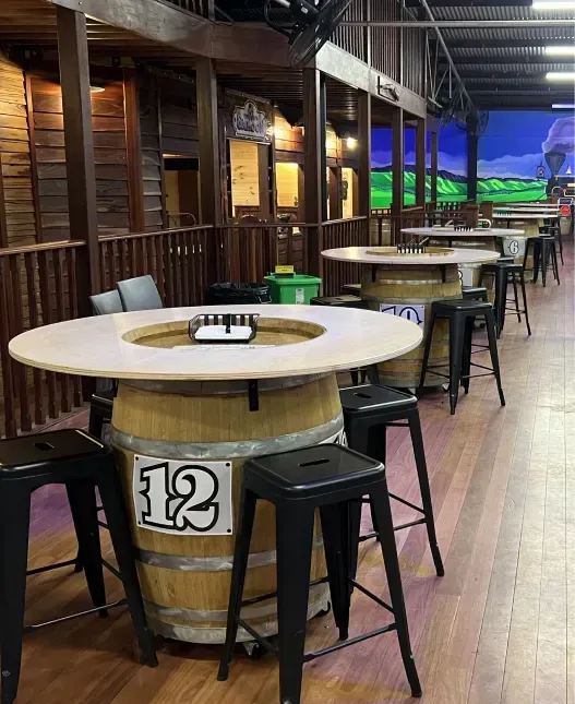 Barrel tables and bar stools in the saloon area.