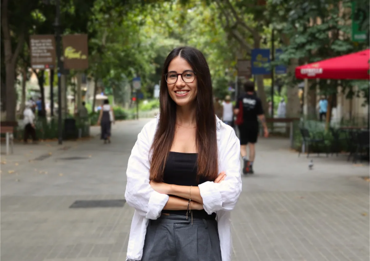 Mujer adulta joven, cabello rizado, sonrisa cálida, fondo neutro, estilo retrato profesional, luz suave