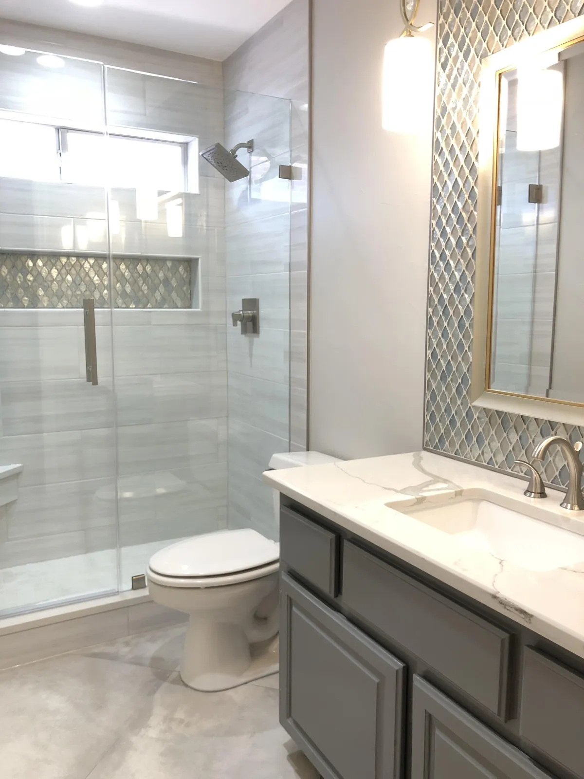 a large kitchen with a marble island and white cabinets