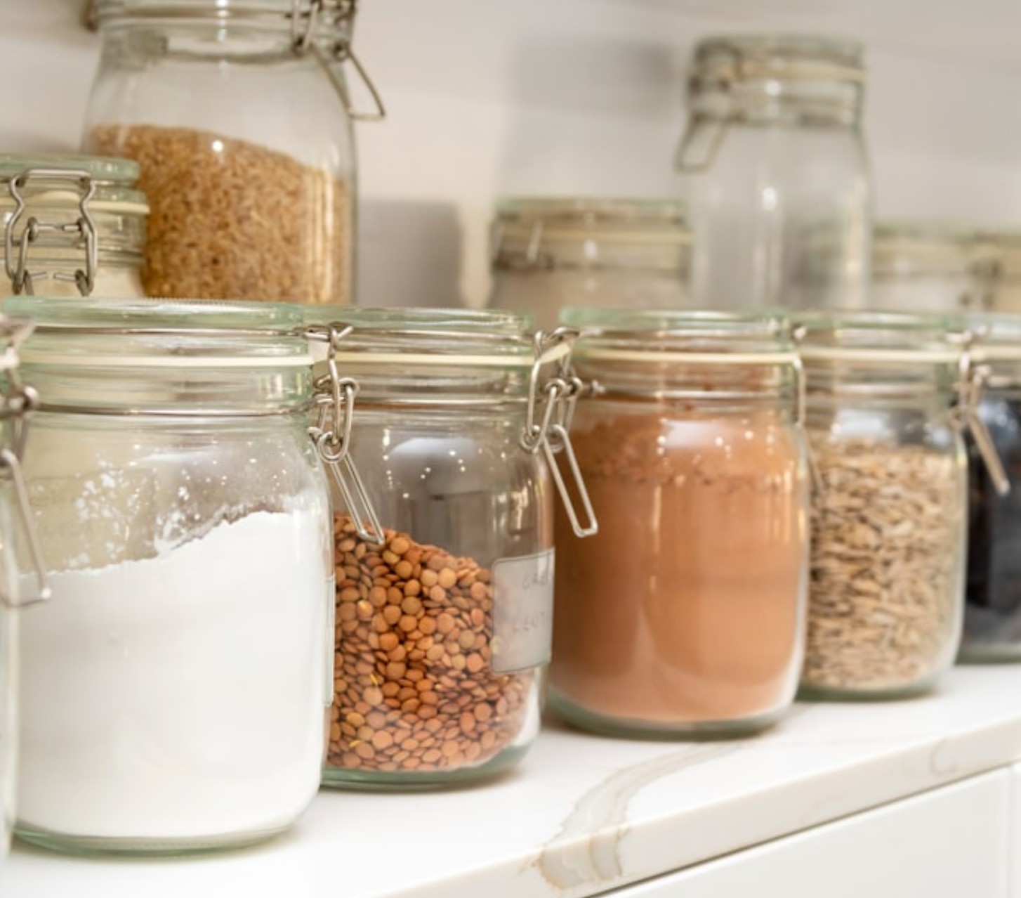 organized kitchen jars on white countertop with Straighten up Homes
