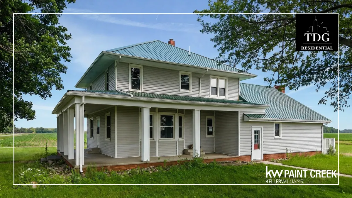Country farmhouse for sale at 28780 School Section Rd, Richmond, MI 48062 on a spacious parcel with a covered front porch and mature trees, listed by The Delia Group.