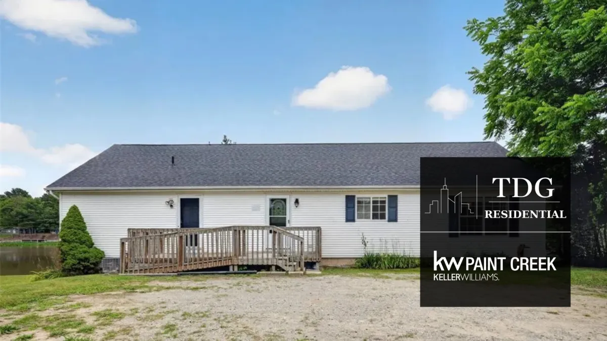 Smallwood Lake waterfront ranch for sale at 533 White Rd, Gladwin Michigan 48624, with a sandy shoreline, dock, and covered deck, listed by The Delia Group.