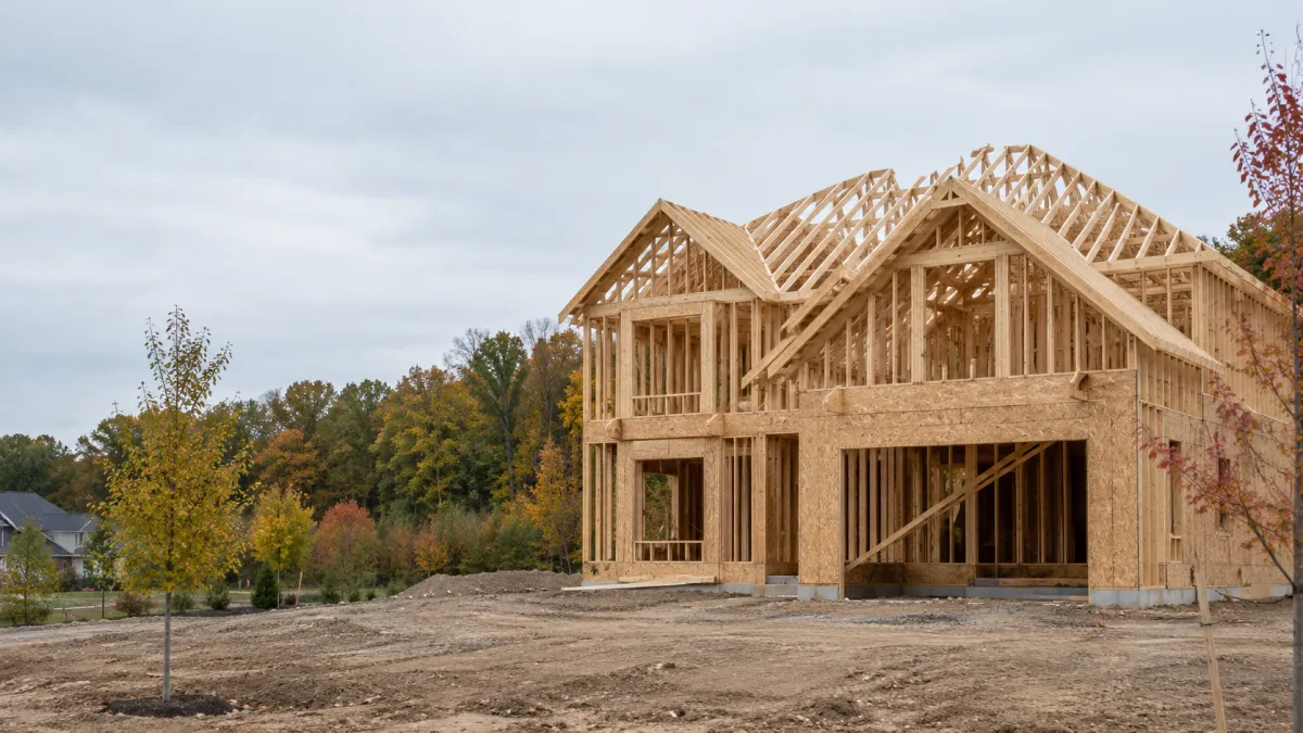 A partly framed new construction house on a graded lot in a new development in Oakland County, Michigan