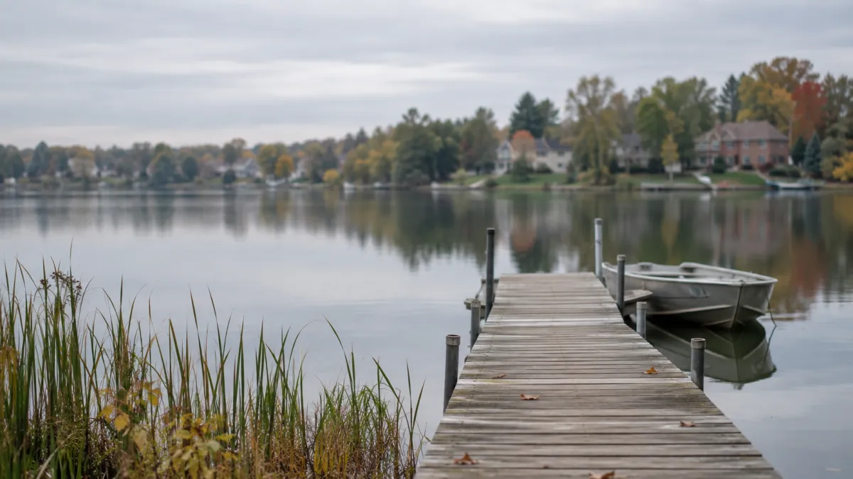 A wooden dock on a calm lake in West Bloomfield, Michigan, the kind of property a seller weighs when comparing the best real estate agent options