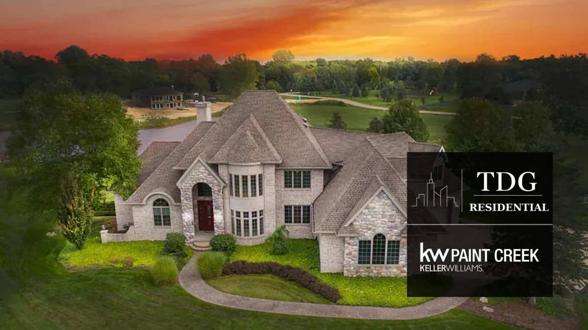 Pond-view custom brick-and-stone home in Okemos with a two-story great room, finished walkout, radiant heat, Ipe decking, and outdoor spa.