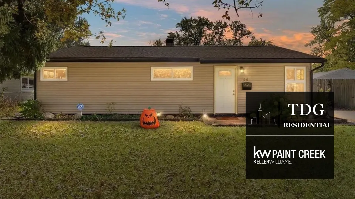 Light-filled Ypsilanti home with solar panels, wood floors, brick fireplace, expansive patio, attached garage, and Ford Lake trails nearby.