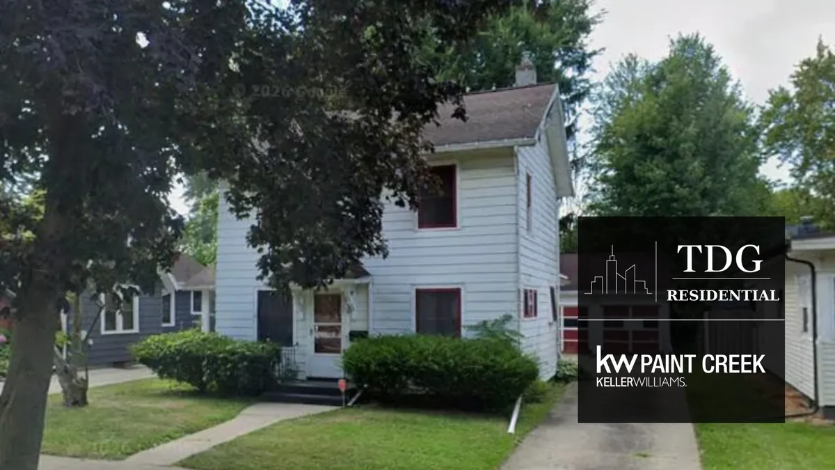 Exterior view of the house at 434 Orange St, Jackson Michigan 49202, showing its front yard and driveway, listed by The Delia Group.