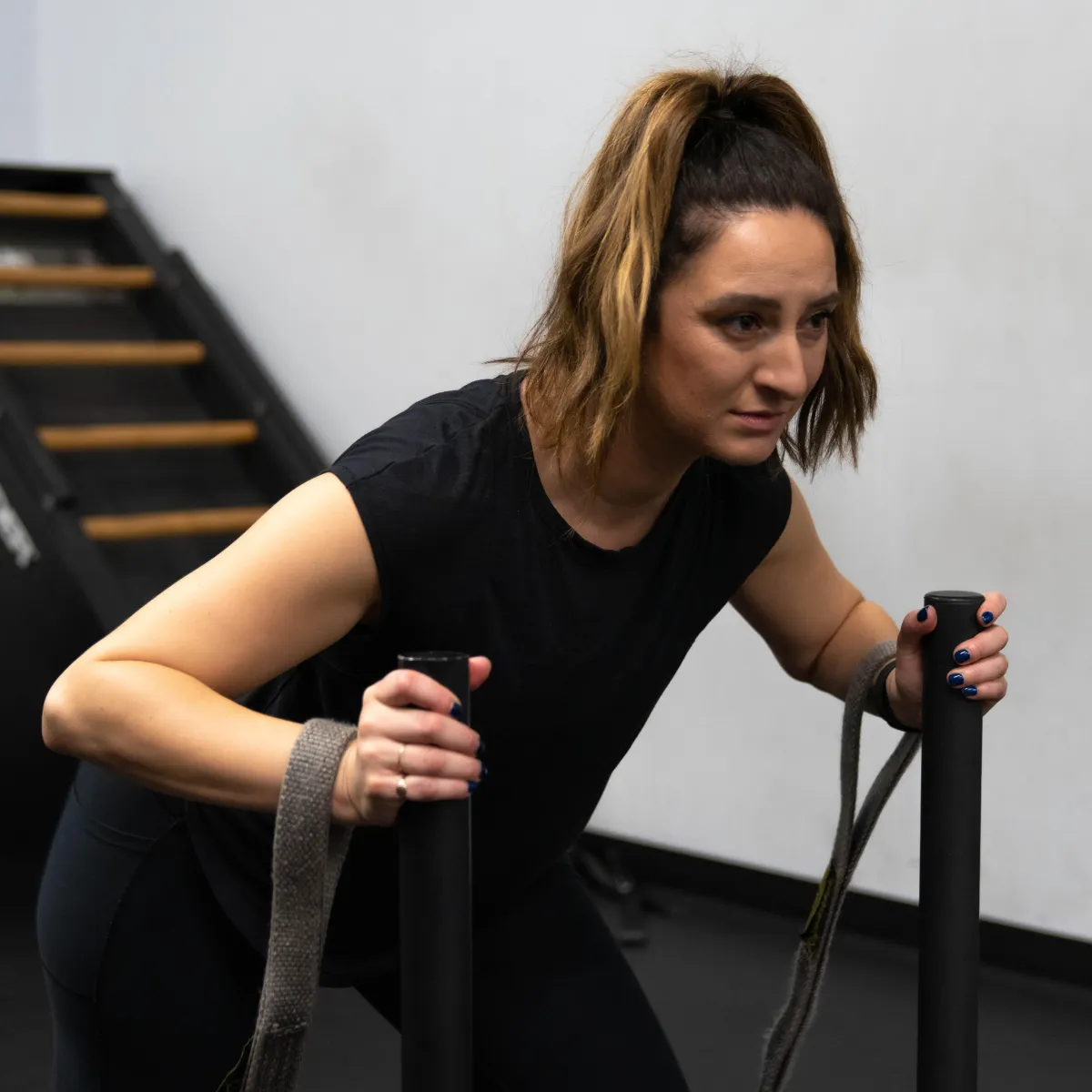 Female performing sled pushes and drags for exercise