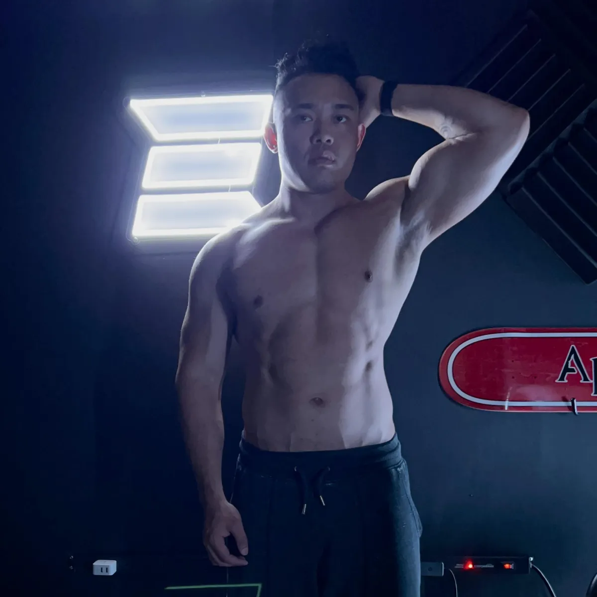 muscular male posing in dim lit room