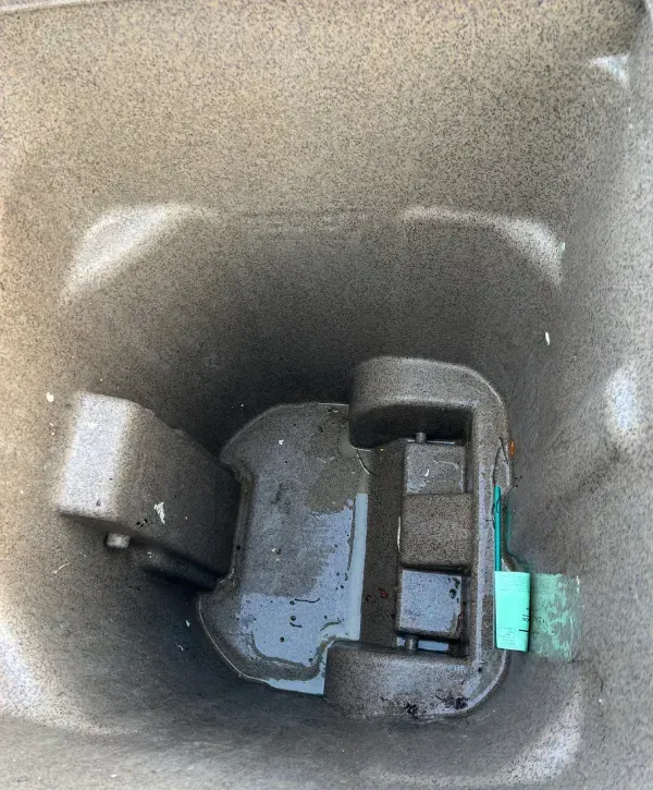 Inside of a brown garbage bin freshly cleaned and rinsed.