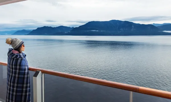Alaskan cruise, woman overlooks the beautiful scenery from her luxury Alaskan cruise - Luxury Sassy Cruises