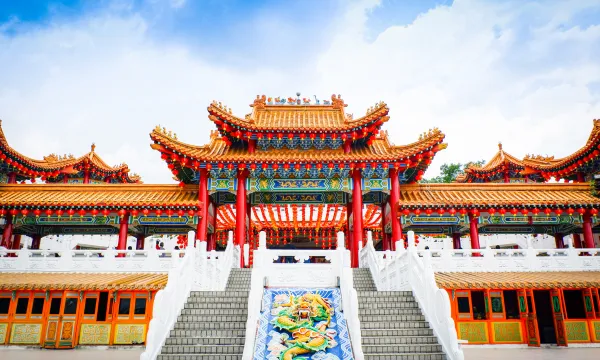 A vibrant, ornate temple with red pillars and intricate gold detailing under a blue sky, representing Asia’s rich cultural heritage and must-see landmarks on a Sassy Luxury Cruise.