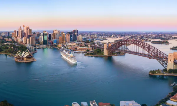  Sydney Opera House and Harbour Bridge illuminated at sunset with city skyline - Luxury Sassy Cruises
