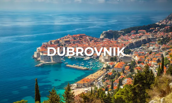 Panoramic view of Dubrovnik’s red-tiled Old Town and medieval city walls overlooking the turquoise Adriatic Sea.