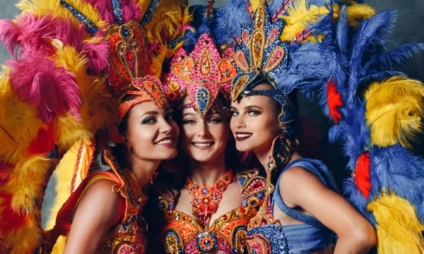 Alt: “Masked samba dancers in colorful costumes parade down a crowded street in Rio de Janeiro during Carnival, confetti flying in the air.”