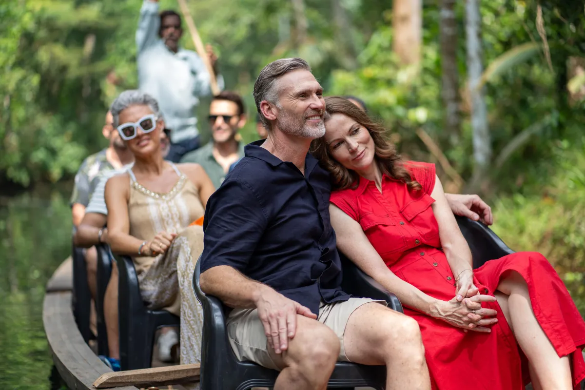 Couple relaxing on a small-group boat tour through lush jungle canals with fellow travellers.