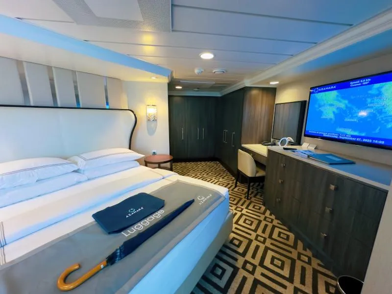Owner’s Suite bedroom on Azamara with plush king-size bed, high-end finishes, and widescreen entertainment.