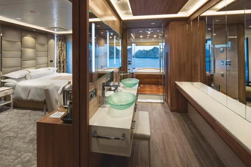 Elegant Owner’s Suite with spa-style bathroom, ocean-view soaking tub, and luxury bedding.