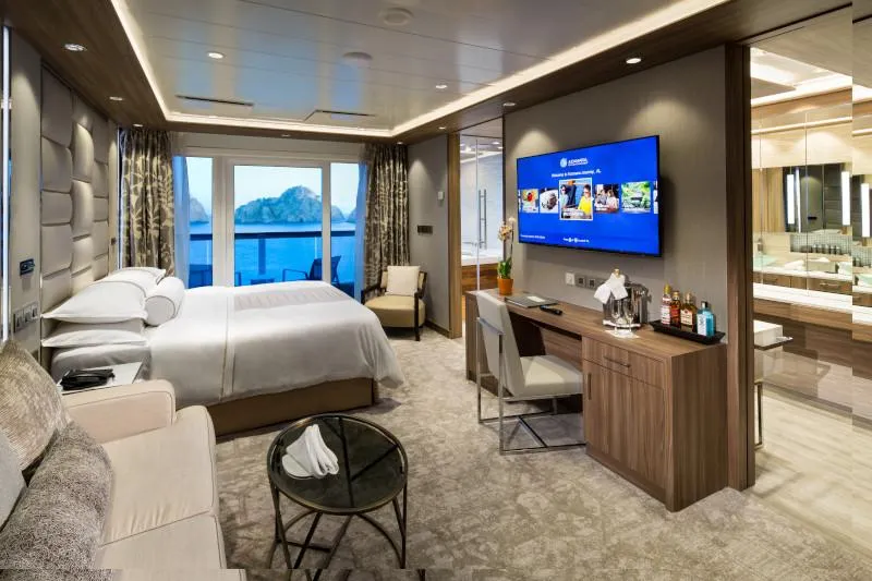 Modern Owner’s Suite with balcony views, king bed, entertainment center, and luxury workspace.