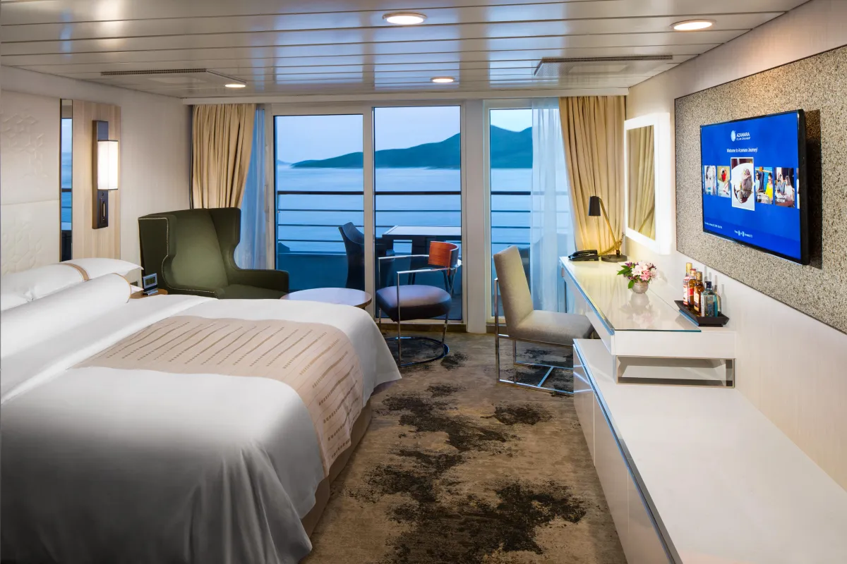Club Continent Suite with elegant king-size bed, floor-to-ceiling balcony doors, and modern decor.