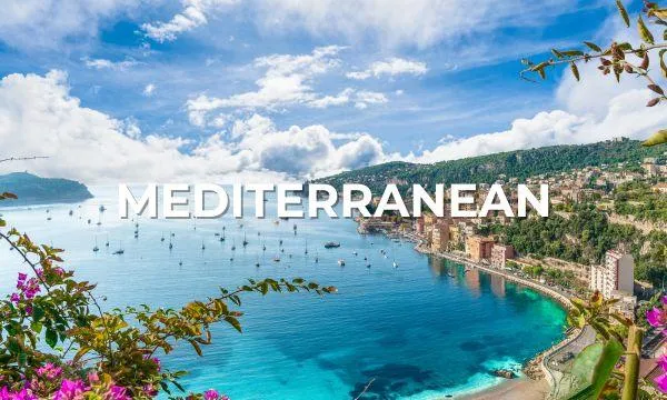 Scenic view of the Italian Riviera with turquoise Mediterranean waters, hillside villages, colourful buildings, and moored yachts – perfect for luxury cruises.