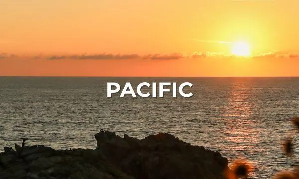 Golden Pacific sunset over the ocean horizon with rocky silhouettes in the foreground – evoking the calm, beauty, and wonder of an Azamara cruise through the Pacific.