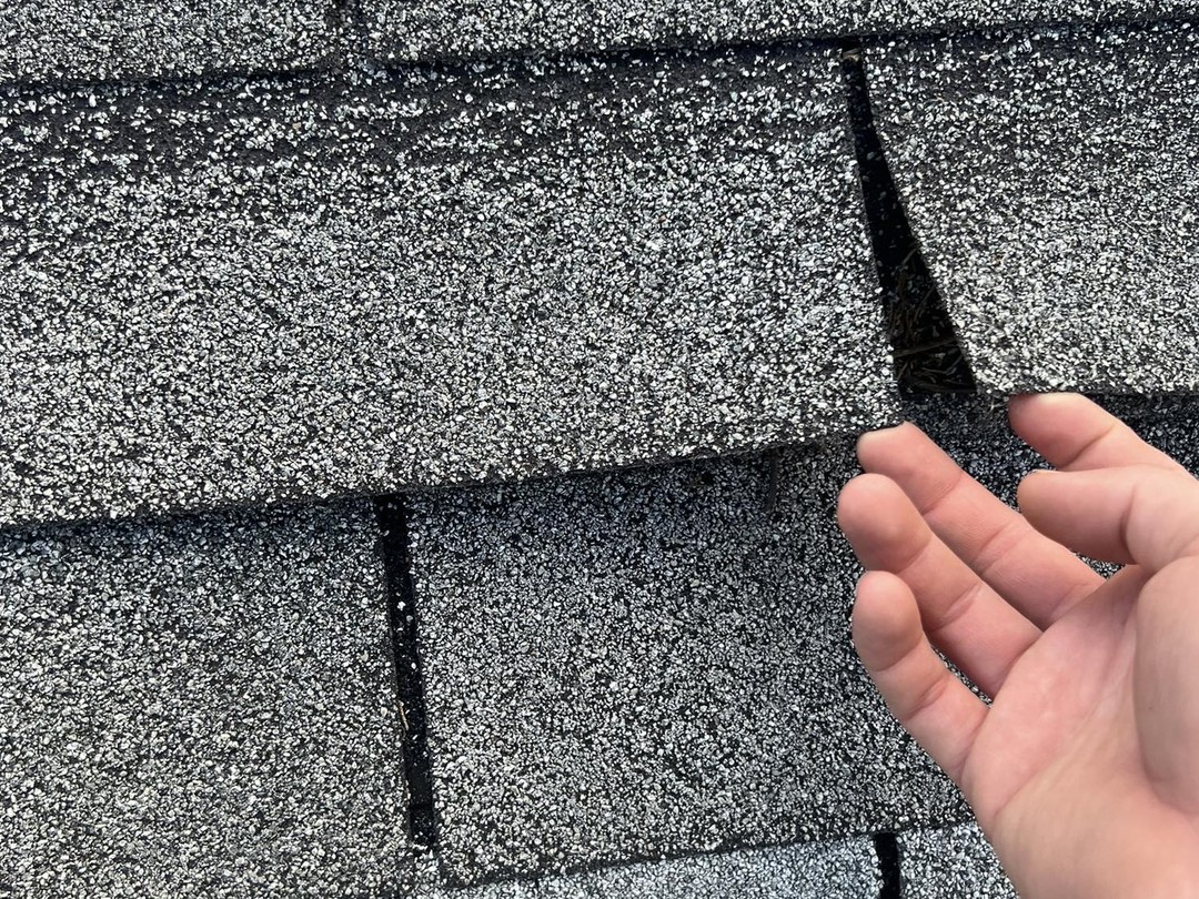 two men working on the roof of a house