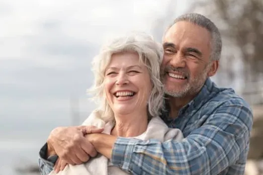 appy senior couple embracing outdoors, symbolizing vitality and wellness from peptide therapy at Hormone Treatment Centers. Peptides support healing, recovery, fat burning, sleep, and hormone balance.