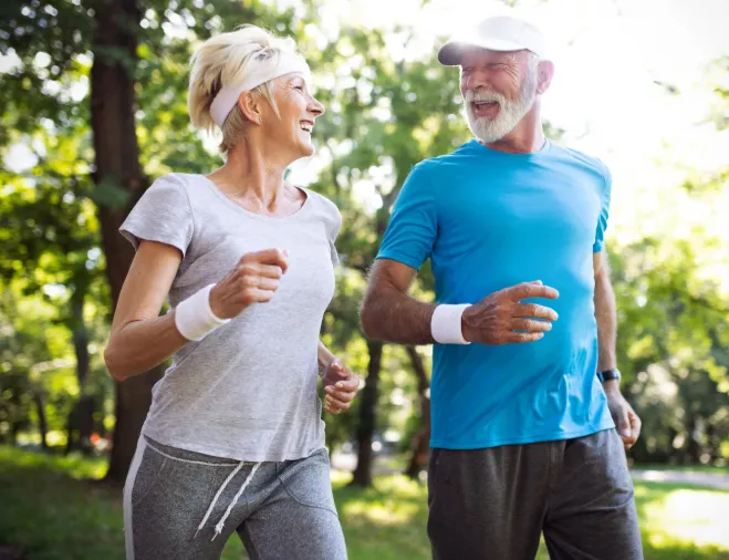 Active mature couple jogging outdoors, representing rapid recovery, tissue repair, and renewed vitality after peptide therapy at Hormone Treatment Centers in Overland Park, KS.