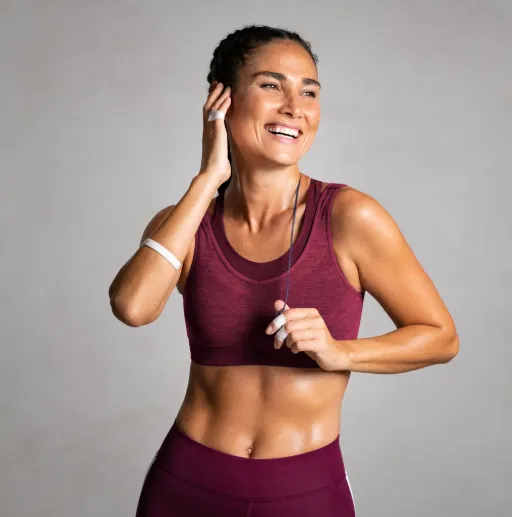 Fit woman smiling after workout, representing increased strength, energy, and recovery achieved through Performance Blend peptide therapy at Hormone Treatment Centers in Overland Park, KS.