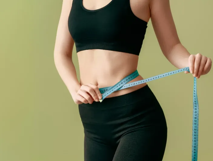 Patient celebrating weight loss success at Hormone Treatment Centers after hormone and metabolic optimization.