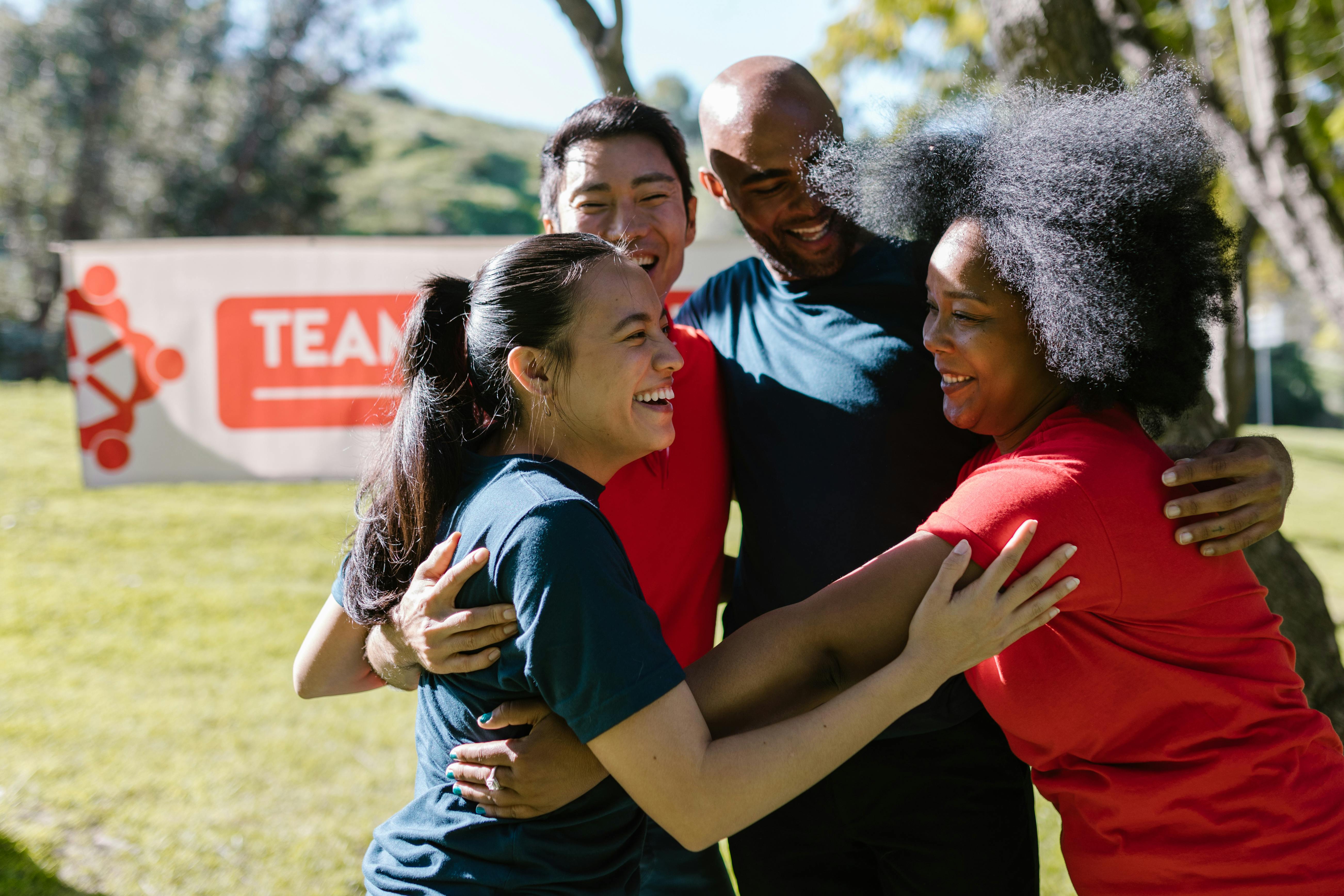 Group of healthy adults smiling and embracing outdoors, representing energy, vitality, and optimized wellness through peptide therapy assessment in Overland Park, KS and Lee’s Summit, MO.