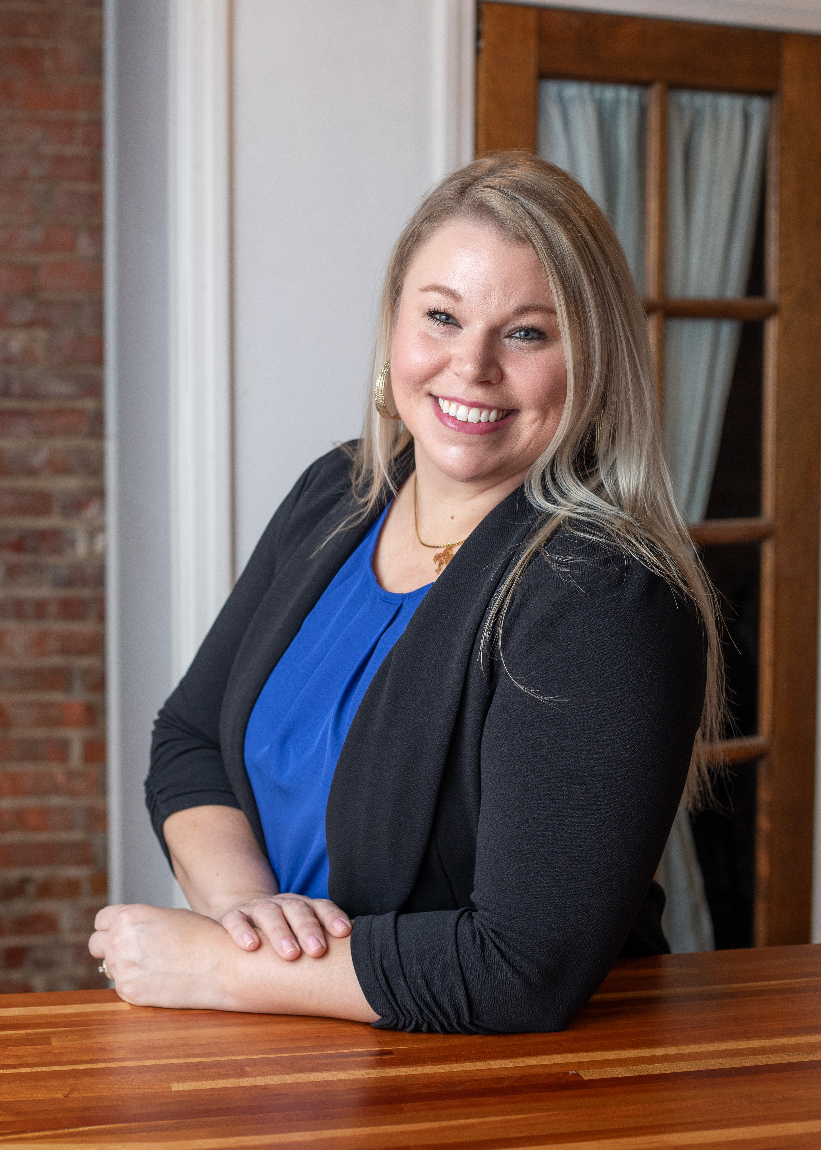 Business portrait of a professional working mother in business attire near brick wall in Illinois