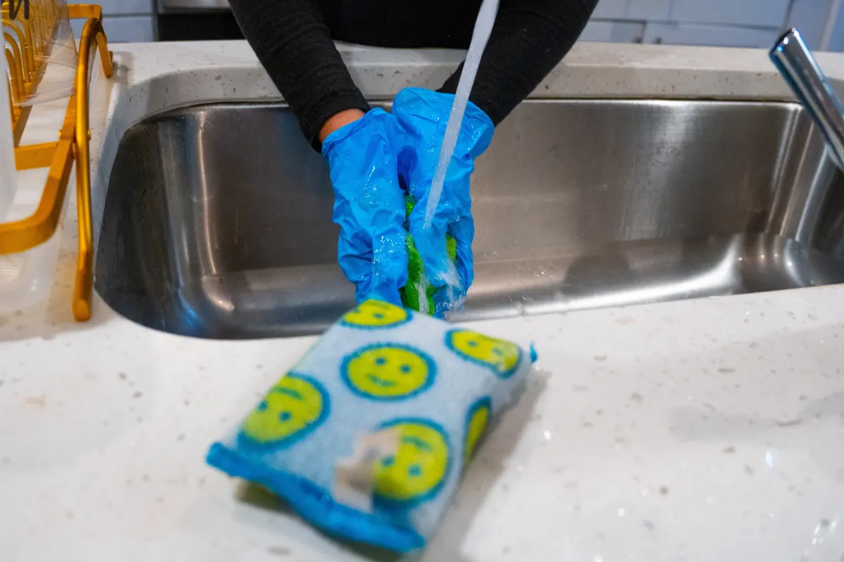 Casita Clean using gloves to rinse cleaning tools during a detailed kitchen clean in Illinois