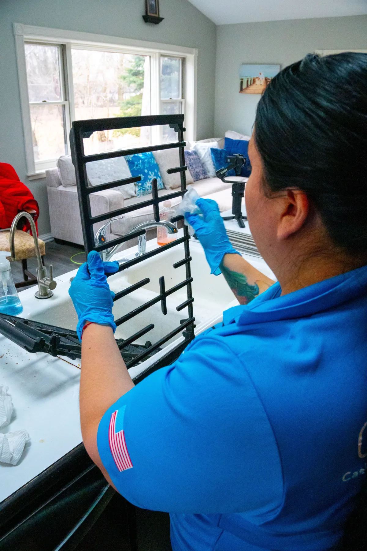 Casita Clean professional scrubbing a stovetop grate at a client’s home in Frankfort, IL